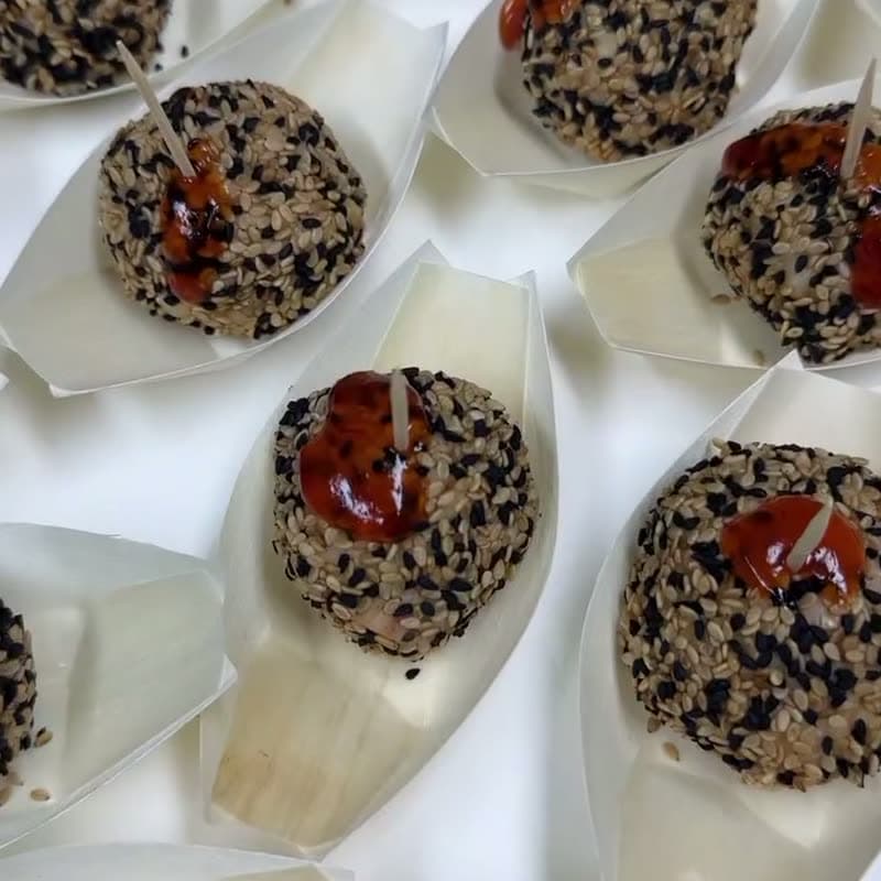 Bouchées au sésame noir servies sur des cuillères de dégustation